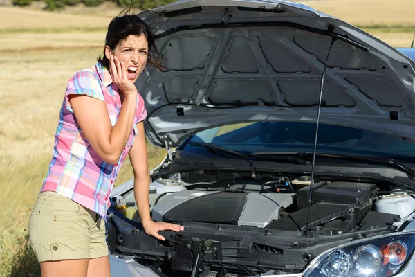 Woman checking broken car engine