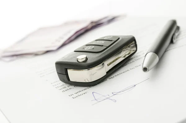 Car key on a contract of car sale