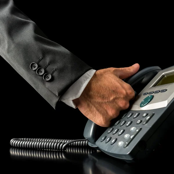 Hand of a businessman picking up the receiver