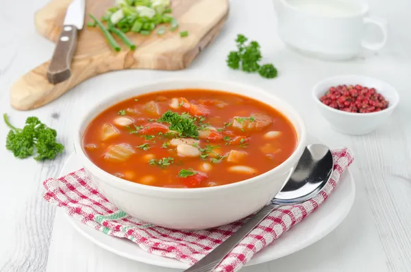 Bowl of roasted tomato soup with beans, celery and sweet pepper