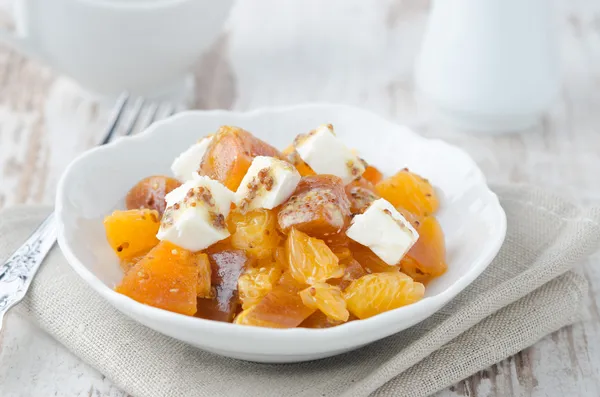 Salad with persimmon, mandarin oranges and goat cheese