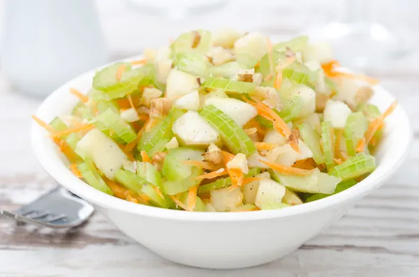 Salad with celery, carrots and apples closeup
