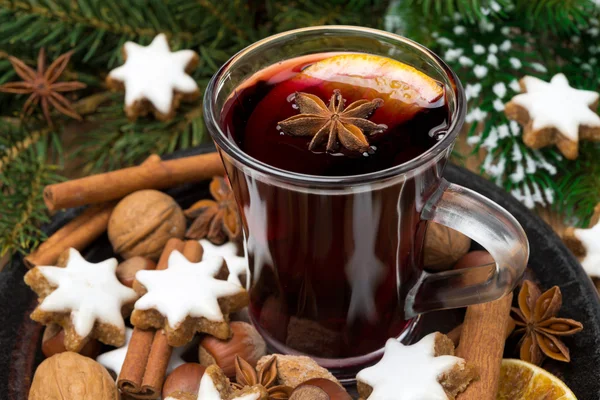 Cup of mulled wine, cookies in the shape of stars and spices