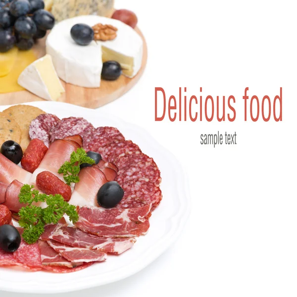 Assorted deli meats and a plate of cheese and grapes, isolated