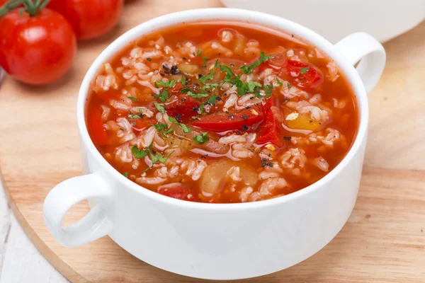 Tomato soup with rice, vegetables and herbs, top view