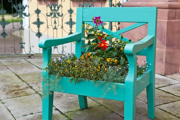 Green old chair decorated with colorful flowers — Stock Photo #13289157