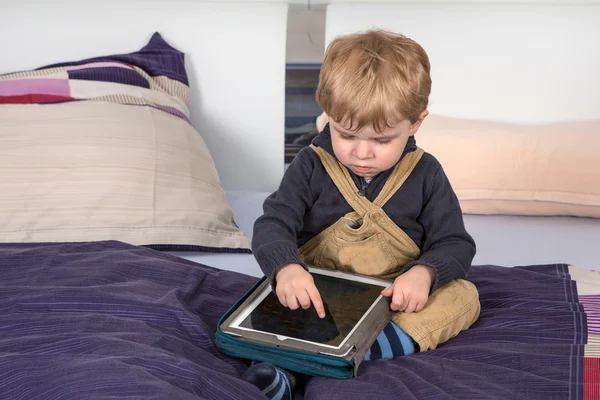 Little toddler boy playing with tablet pc
