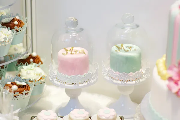Detail of sweet table on wedding with cupcakes and bride and gro
