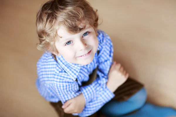 Portrait of adorable little boy with blond hairs and blue eyes