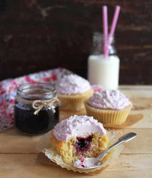 Three cupcakes with blackcurrant jam and coconut