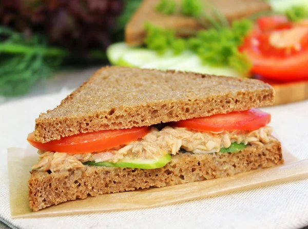 Sandwich with rye brown bread, ripe tomatoes, cucumbers and tuna fish for healthy snack