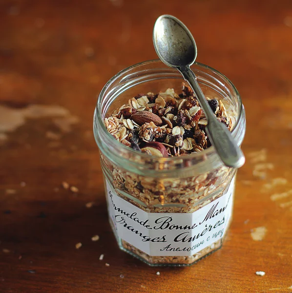 Homemade organic granola with rolled oat flakes, caramelized almonds, cashew, hazelnuts, dried apricots, raisin and dates with banana chips in a breakfast bowl