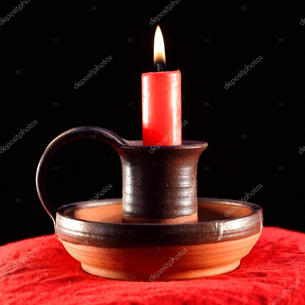 Red candle in ancient ceramic candlestick. — Stock Photo © vladvitek