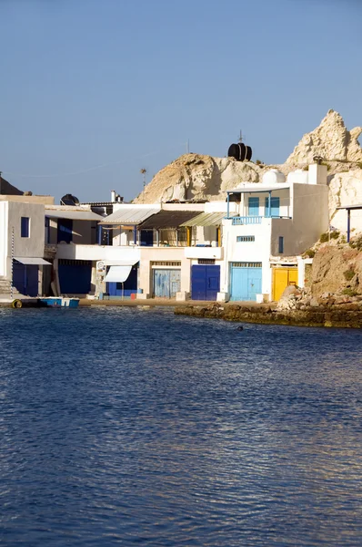 Fisherman houses boat storage garages built into rock cliffs on Mediterranean Sea Firopotamos Milos Cyclades Greek Island Greece
