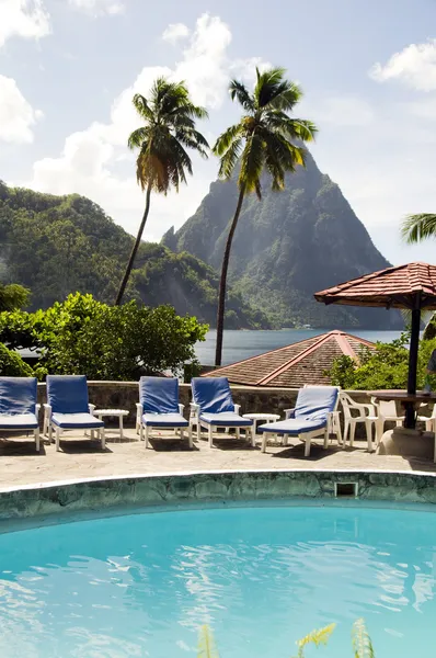 Caribbean Sea resort swimming pool view twin piton peaks mountains with coconut palm trees Soufriere St. Lucia