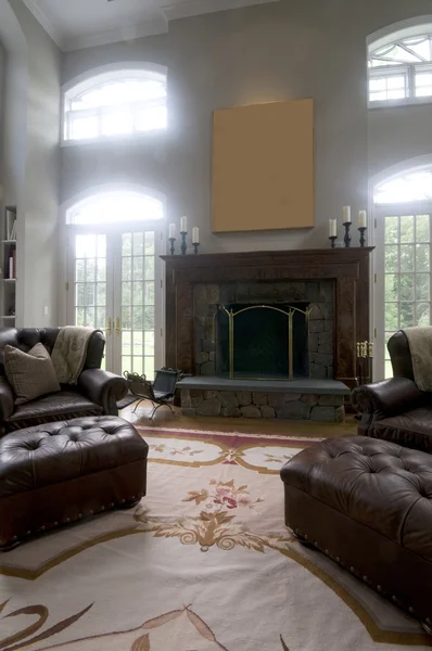 Large living room with leather chairs and fireplace