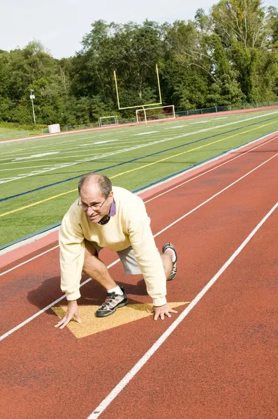Middle age senior man exercising running on sports field and run
