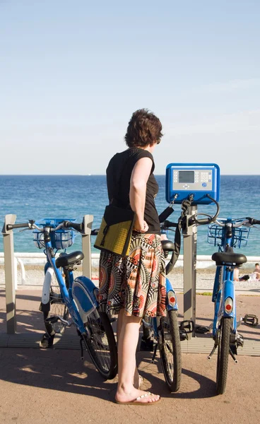 Tourist looking at bicycle rental machine Nice France