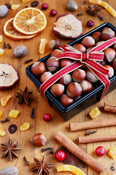 Decoration hazelnut in baking pan and mixed spices and dried fru