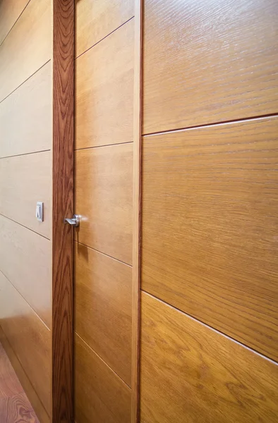 Wooden wall with door and a light switch