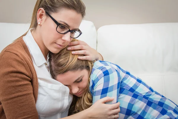 Mother embracing and soothes depressed daughter