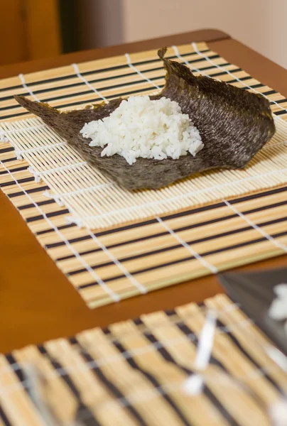 Nori seaweed sheet with rice above to make sushi