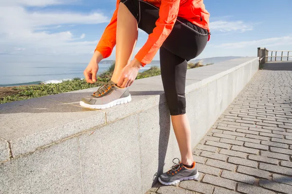 Closeup of female hands tying running shoes laces