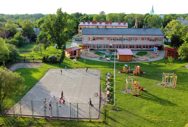 Bird view of children playing in the playground near the kindergarten