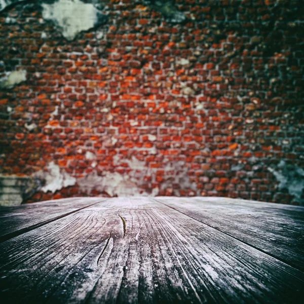 Empty wooden table with old brick wall