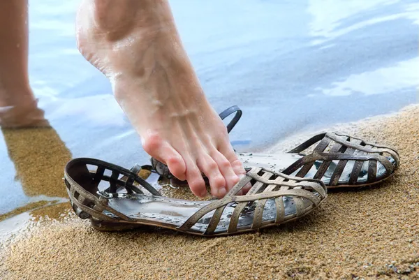 Women's feet resting on a beach