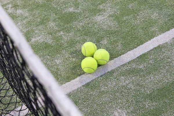 Tennis or paddle balls on synthetic grass of paddle court