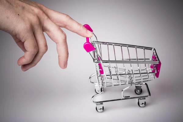 Pink shopping cart in woman hand