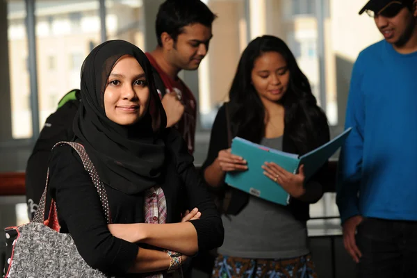 Young Arab Student holding books in College Campus