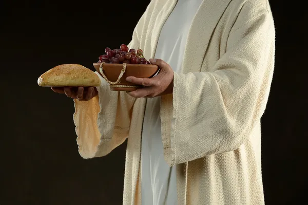 Jesus holding a bread and grapes