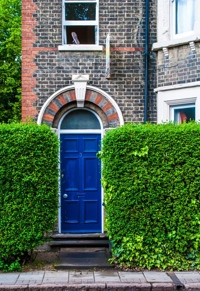 An arched blue door of a victorian english house