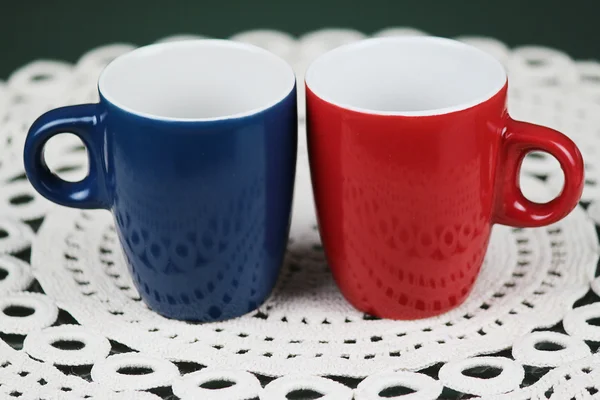Red and blue mugs espresso stand on vintage napkin