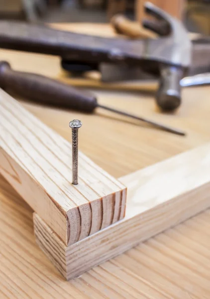 Hammer and nail in wood table