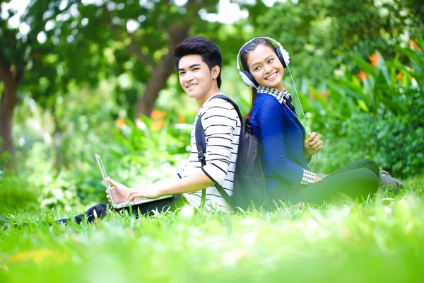 Young Asian students with computer and smile in outdoor
