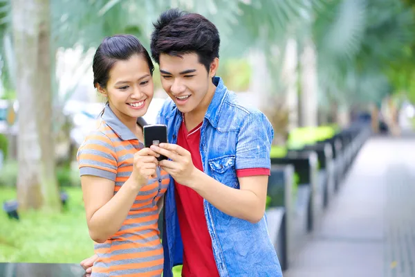 Young Asian couple with phone in outdoor