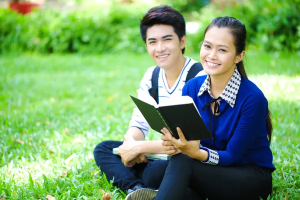 Young Asian students with books and smile in outdoor