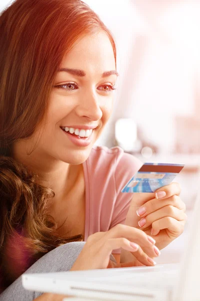 Happy teenager woman using credit card shopping online laptop co