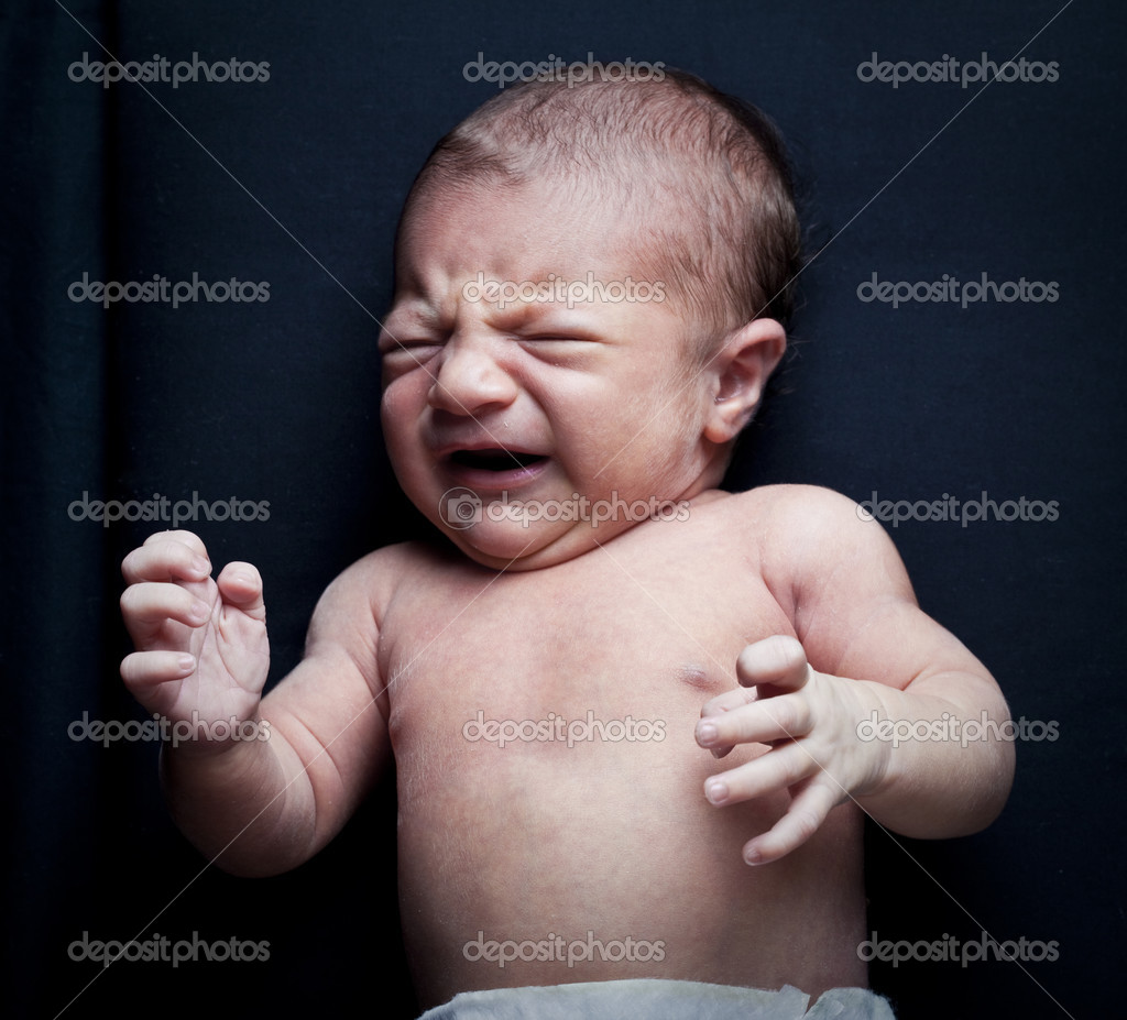 Portrait of adorable newborn baby girl crying on black