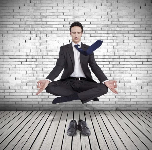 Young businessman levitating in yoga position, meditation