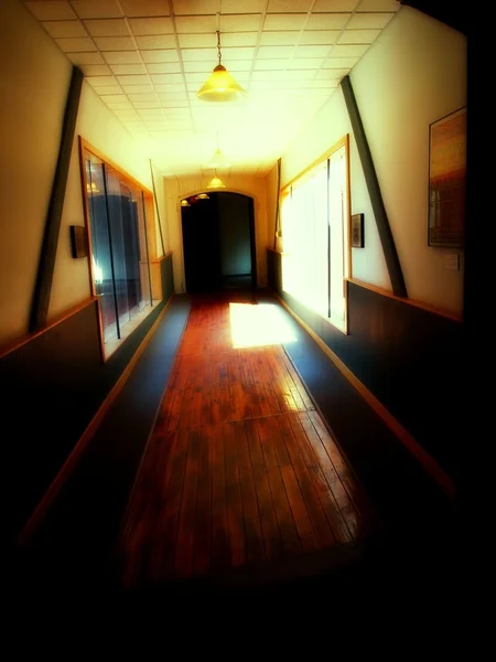 Spooky hallway with windows and a dark door
