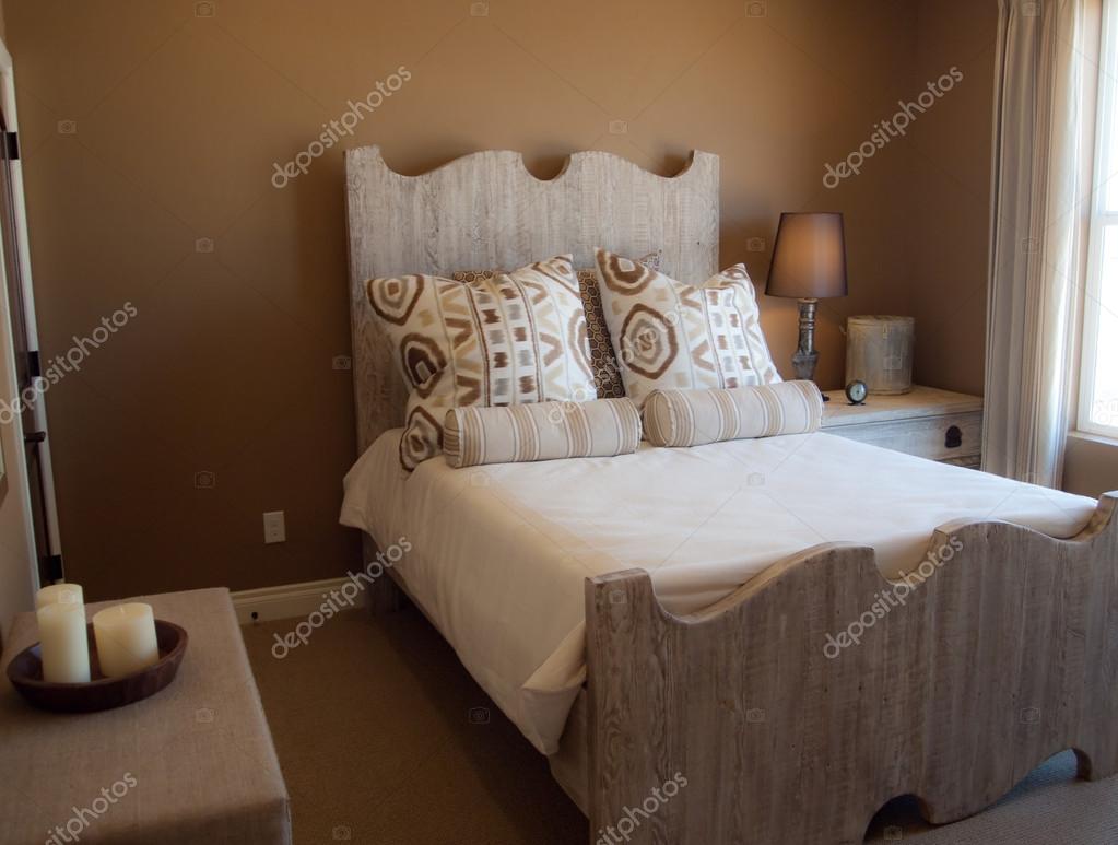 Rustieke slaapkamer met bruine muren en houten bed frame ...
