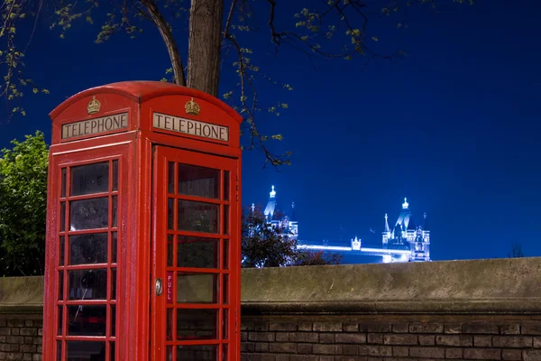 Red telephone and Tower Bridge at night, London, England