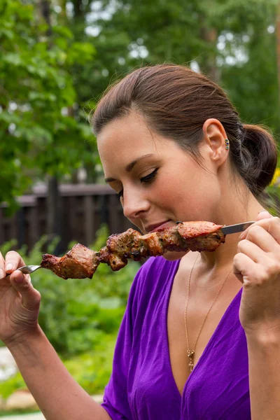 Woman enjoying barbecue outdoors — Stock Photo #31807815