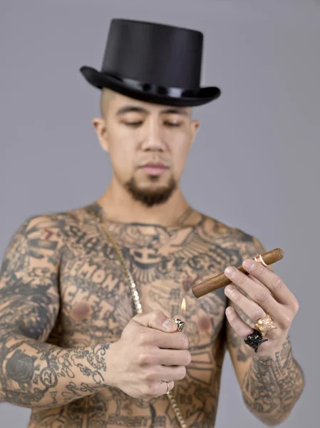 Man with body tattoo with cigar