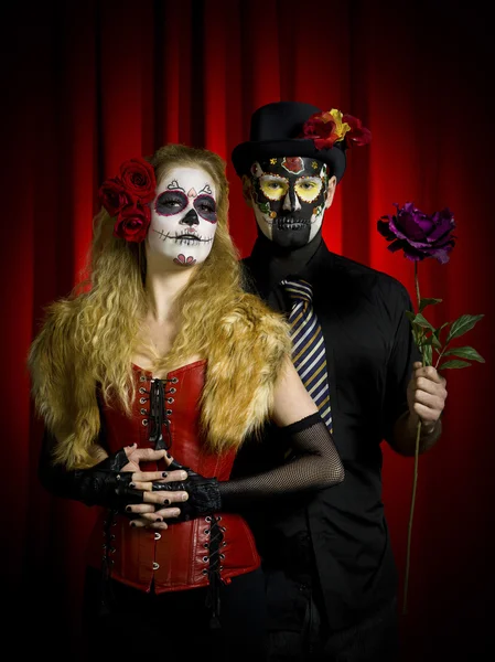 Portrait of a scary couple posing over red background
