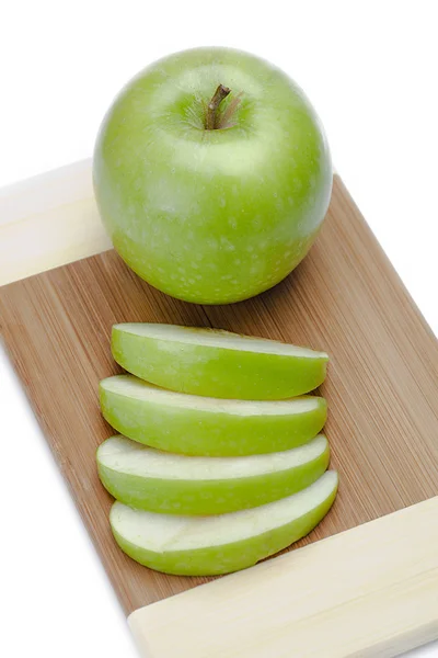 A green apple with some apple slices